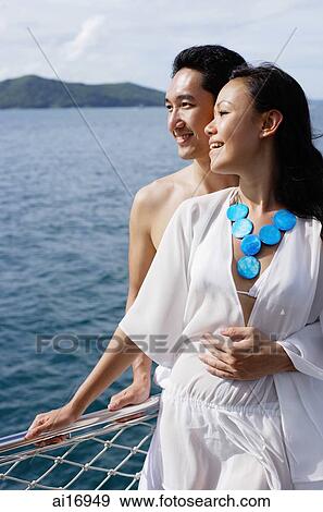 Couple standing on yacht, man with arm around woman View Large Photo Image Stock Photo - Couple standing on yacht, man with arm around woman . Fotosearch