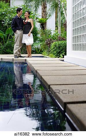 Couple standing side by side next to swimming pool View Large Photo Image Stock Image - Couple standing side by side next to swimming pool . Fotosearch