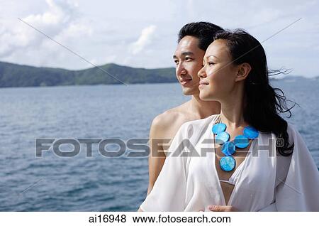 Couple standing together, cheek to cheek, looking away View Large Photo Image Stock Photo - Couple standing together, cheek to cheek, looking away . Fotosearch