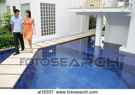 Couple walking by swimming pool, holding hands View Large Photo Image Stock Photo - Couple walking by swimming pool, holding hands . Fotosearch