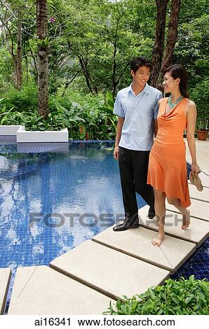 Couple walking side by side by swimming pool View Large Photo Image Stock Image - Couple walking side by side by swimming pool . Fotosearch
