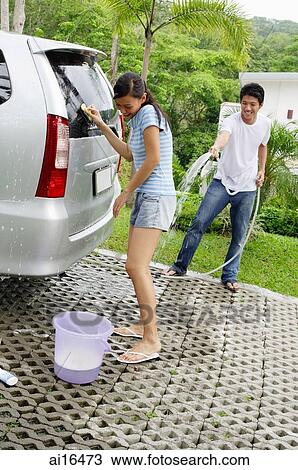Couple washing car, man spraying woman with water View Large Photo Image Stock Image - Couple washing car, man spraying woman with water . Fotosearch