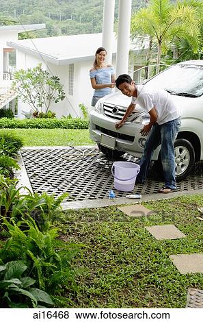 Couple washing car, smiling at camera View Large Photo Image Stock Photo - Couple washing car, smiling at camera . Fotosearch