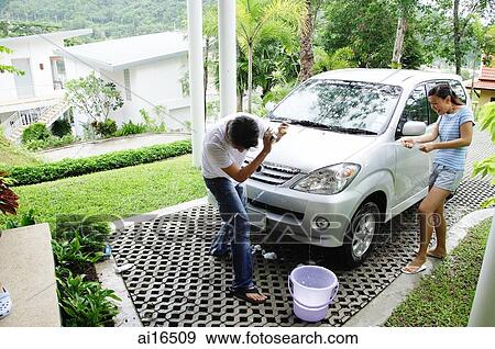 Couple washing car, woman spraying man with water View Large Photo Image Stock Photo - Couple washing car, woman spraying man with water . Fotosearch
