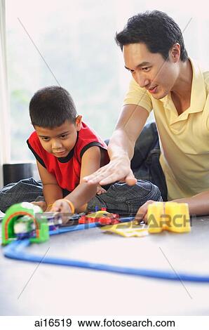 Father and son playing with train set View Large Photo Image Stock Photo - Father and son playing with train set. Fotosearch