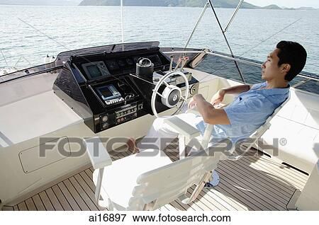 Man at helm of yacht View Large Photo Image Stock Photo - Man at helm of yacht . Fotosearch