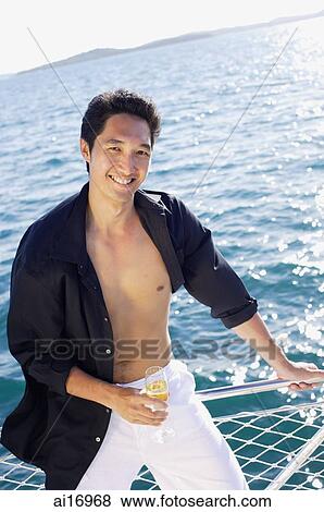 Man on boat, leaning on railing, smiling at camera View Large Photo Image Stock Photo - Man on boat, leaning on railing, smiling at camera . Fotosearch