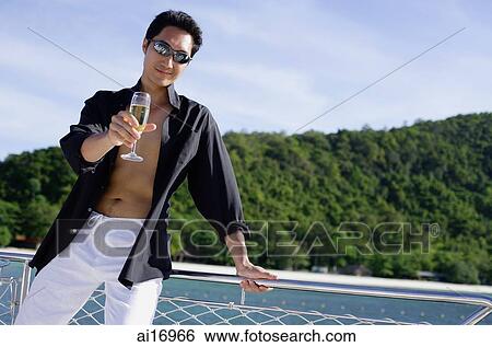 Man on boat, leaning on railing, holding drink out towards camera View Large Photo Image Stock Photograph - Man on boat, leaning on railing, holding drink out towards camera. Fotosearch