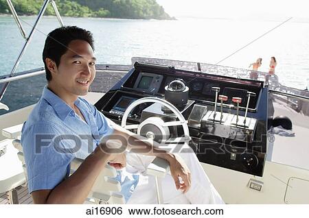 Man sitting at helm of yacht, looking at camera View Large Photo Image Stock Photograph - Man sitting at helm of yacht, looking at camera . Fotosearch