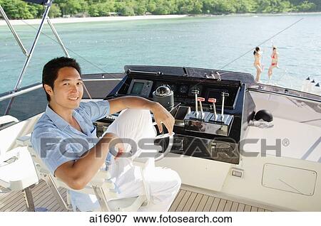 Man sitting at helm of yacht, portrait View Large Photo Image Stock Photo - Man sitting at helm of yacht, portrait . Fotosearch