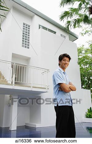 Man standing outside house, arms crossed View Large Photo Image Stock Photograph - Man standing outside house, arms crossed . Fotosearch