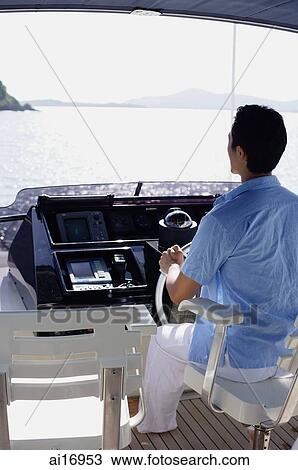Man steering yacht, rear view View Large Photo Image Stock Image - Man steering yacht, rear view . Fotosearch