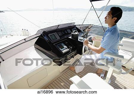 Man steering yacht View Large Photo Image Stock Photograph - Man steering yacht . Fotosearch