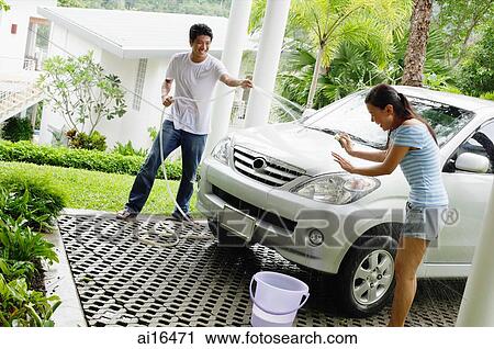 Man washing car and spraying water onto woman View Large Photo Image Stock Image - Man washing car and spraying water onto woman . Fotosearch