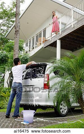 Man washing car, woman standing on balcony looking down at him View Large Photo Image Stock Photography - Man washing car, woman standing on balcony looking down at him . Fotosearch