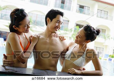 One man between two woman dressed in bikinis View Large Photo Image Picture - One man between two woman dressed in bikinis . Fotosearch