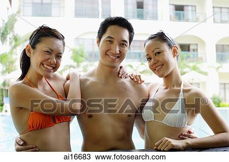 One man standing between two woman dressed in bikinis View Large Photo Image Stock Image - One man standing between two woman dressed in bikinis . Fotosearch