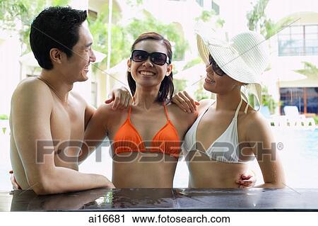 Two women and one man in swimwear, arms around each other View Large Photo Image Stock Image - Two women and one man in swimwear, arms around each other . Fotosearch