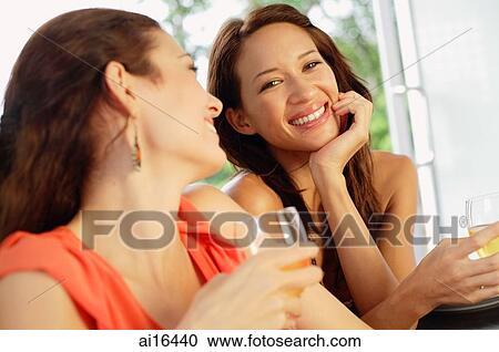 Two women with wine glasses, one smiling at camera View Large Photo Image Stock Image - Two women with wine glasses, one smiling at camera . Fotosearch