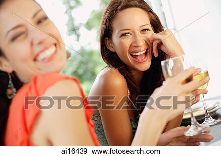 Two women with wine glasses, smiling at camera View Large Photo Image Stock Photo - Two women with wine glasses, smiling at camera . Fotosearch