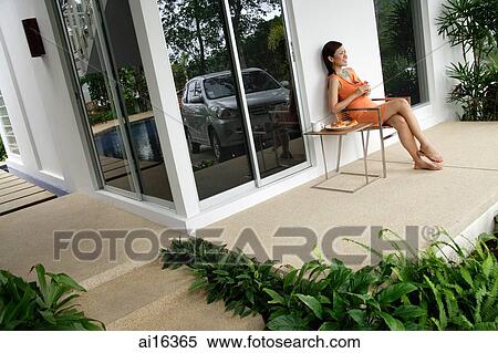 Woman at home, sitting and having coffee on patio View Large Photo Image Stock Photography - Woman at home, sitting and having coffee on patio . Fotosearch