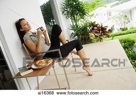 Woman having coffee on patio View Large Photo Image Stock Photo - Woman having coffee on patio . Fotosearch