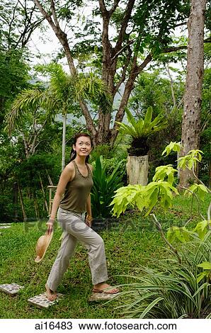 Woman in garden, stepping on stones View Large Photo Image Stock Image - Woman in garden, stepping on stones. Fotosearch