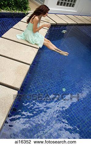 Woman in green dress sitting by pool, legs in the water View Large Photo Image Stock Image - Woman in green dress sitting by pool, legs in the water . Fotosearch