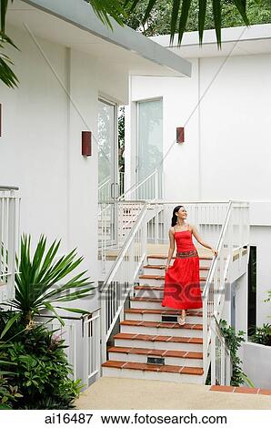 Woman in red dress walking down stairs View Large Photo Image Stock Photo - Woman in red dress walking down stairs. Fotosearch