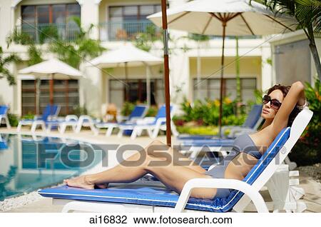 Woman in swimwear, sitting on deck chair View Large Photo Image Stock Image - Woman in swimwear, sitting on deck chair . Fotosearch