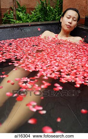 Woman in tub filled with floating rose petals View Large Photo Image Picture - Woman in tub filled with floating rose petals . Fotosearch