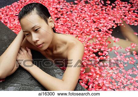Woman leaning at edge of tub filled with floating rose petals View Large Photo Image Stock Image - Woman leaning at edge of tub filled with floating rose petals . Fotosearch