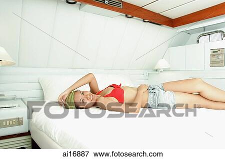 Woman lying on bed in yacht cabin View Large Photo Image Stock Photo - Woman lying on bed in yacht cabin . Fotosearch
