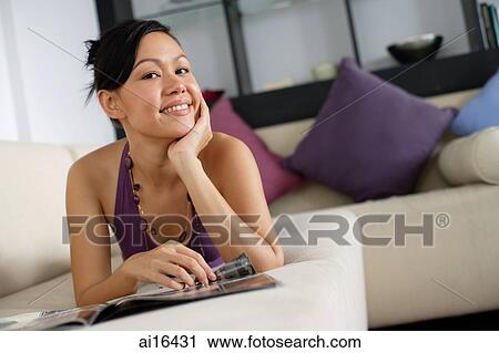 Woman lying on sofa, looking at camera, smiling, hand on chin View Large Photo Image Stock Image - Woman lying on sofa, looking at camera, smiling, hand on chin. Fotosearch