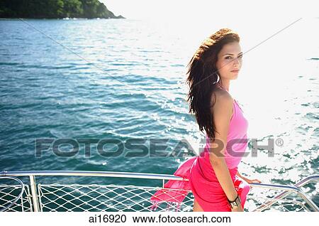 Woman on boat, standing next to railing, looking at camera View Large Photo Image Stock Image - Woman on boat, standing next to railing, looking at camera. Fotosearch