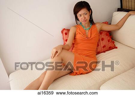 Woman sitting on sofa View Large Photo Image Stock Photo - Woman sitting on sofa . Fotosearch
