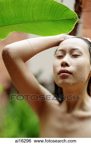 Stock Photograph - Woman taking an outdoor shower, eyes closed. Fotosearch