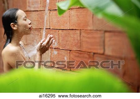 Woman taking an outdoor shower framed by leaves View Large Photo Image Stock Photography - Woman taking an outdoor shower framed by leaves . Fotosearch