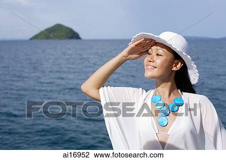 Stock Image - Woman wearing white hat, smiling. Fotosearch