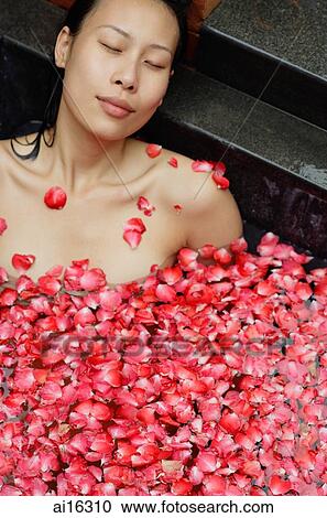 Woman with eyes closed, relaxing in tub with floating rose petals View Large Photo Image Stock Image - Woman with eyes closed, relaxing in tub with floating rose petals . Fotosearch