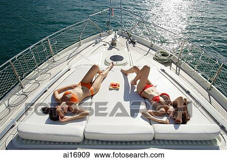 Women sunbathing on boat deck, high angle view View Large Photo Image Stock Photo - Women sunbathing on boat deck, high angle view . Fotosearch