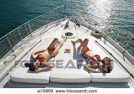 http://fscomps.fotosearch.com/compc/ASI/ASI006/women-sunbathing-on-boat-deck-high-stock-photograph__ai16909.jpg