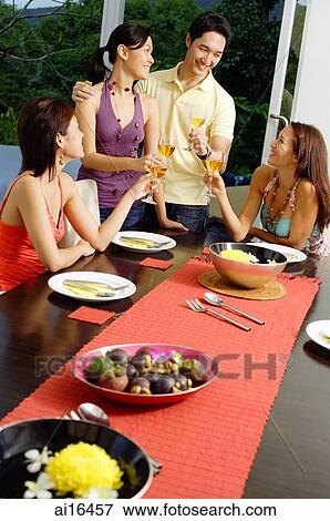 Young adults having dinner party, toasting with wine glasses View Large Photo Image Stock Photo - Young adults having dinner party, toasting with wine glasses. Fotosearch