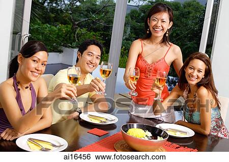 Young adults raising wine glasses, towards camera View Large Photo Image Stock Photograph - Young adults raising wine glasses, towards camera . Fotosearch