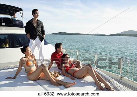 Young adults relaxing on boat deck View Large Photo Image Stock Image - Young adults relaxing on boat deck. Fotosearch