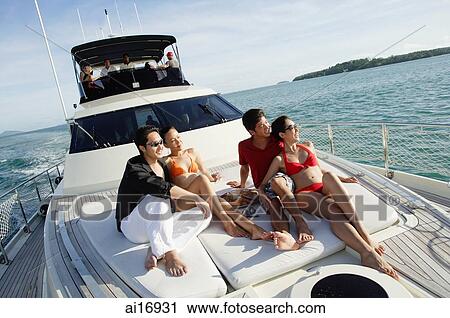 Young adults sitting on boat deck, looking away View Large Photo Image Stock Image - Young adults sitting on boat deck, looking away . Fotosearch
