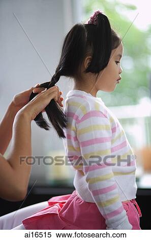 Young girl having her hair braided by mother View Large Photo Image Stock Photography - Young girl having her hair braided by mother . Fotosearch