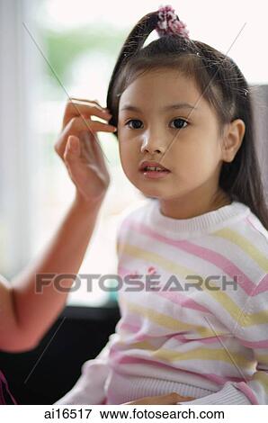 Young girl looking away, mother tucking her hair behind ear View Large Photo Image Stock Photo - Young girl looking away, mother tucking her hair behind ear. Fotosearch
