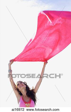 Young woman holding piece of cloth in the air, looking up View Large Photo Image Stock Image - Young woman holding piece of cloth in the air, looking up . Fotosearch