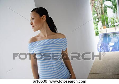 Young woman in striped top, looking away View Large Photo Image Stock Image - Young woman in striped top, looking away . Fotosearch
